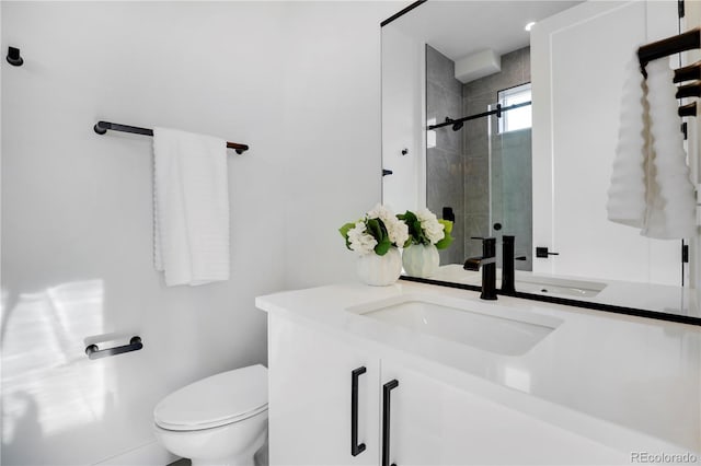 bathroom with a shower stall, toilet, and vanity