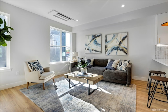 living area with light wood-style floors, baseboards, and recessed lighting