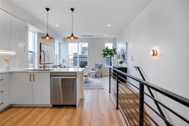 kitchen with dishwasher, a sink, modern cabinets, white cabinetry, and light wood-style floors