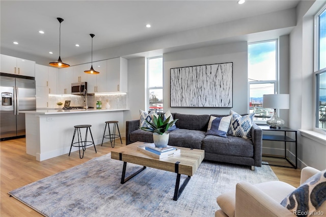 living area with light wood-style floors and recessed lighting