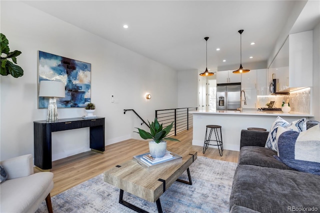 living room with light wood-type flooring and recessed lighting