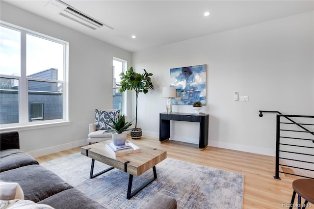 living room featuring light wood-style flooring, baseboards, and recessed lighting