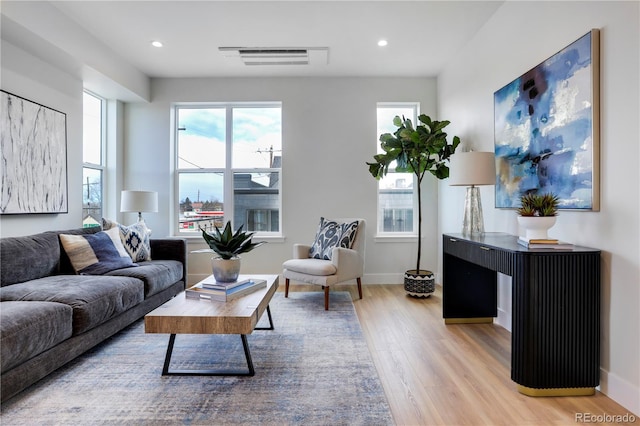 living area with light wood-type flooring, recessed lighting, and baseboards
