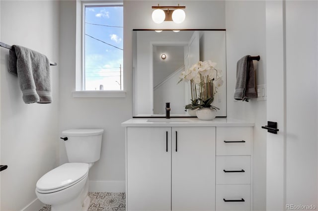 bathroom featuring baseboards, toilet, and vanity