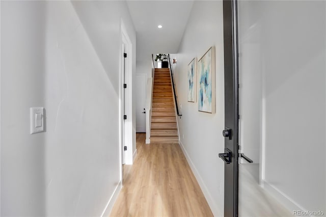 hall with light wood-type flooring, baseboards, stairs, and recessed lighting