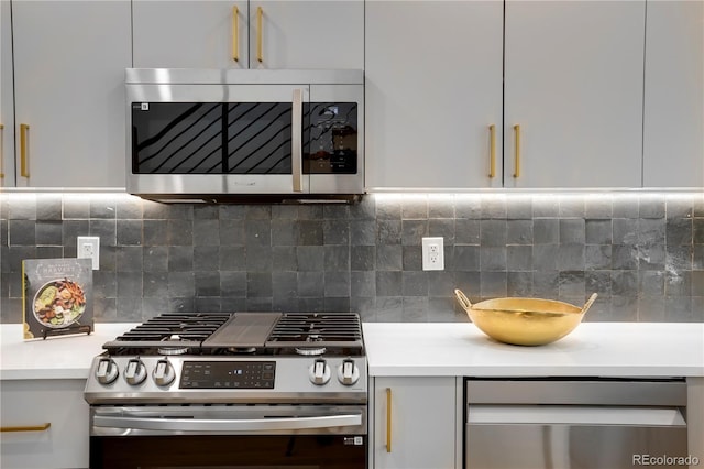 kitchen featuring appliances with stainless steel finishes, light countertops, decorative backsplash, and white cabinets