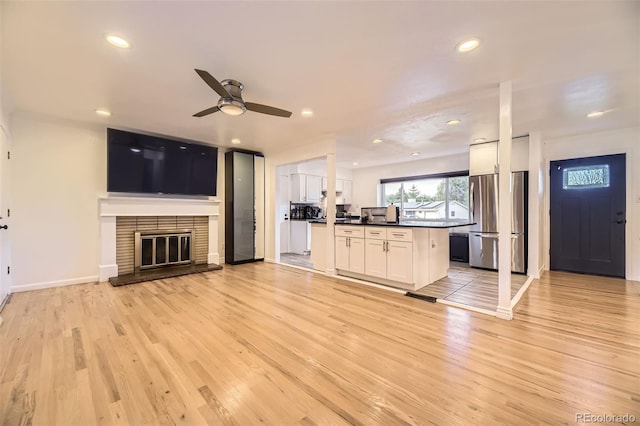4244 W Monmouth Ave, Littleton, CO 80123 - unfurnished living room with light wood-style flooring, ceiling fan, recessed lighting, and a brick fireplace