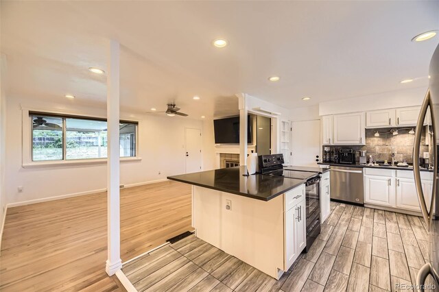 4244 W Monmouth Ave, Littleton, CO 80123 - kitchen with black electric range oven, dark countertops, a ceiling fan, dishwasher, and white cabinets