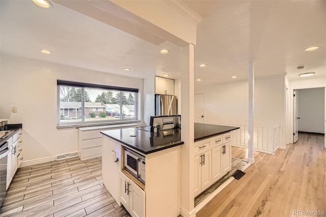 4244 W Monmouth Ave, Littleton, CO 80123 - kitchen with stainless steel appliances, light wood-type flooring, dark countertops, white cabinets, and recessed lighting