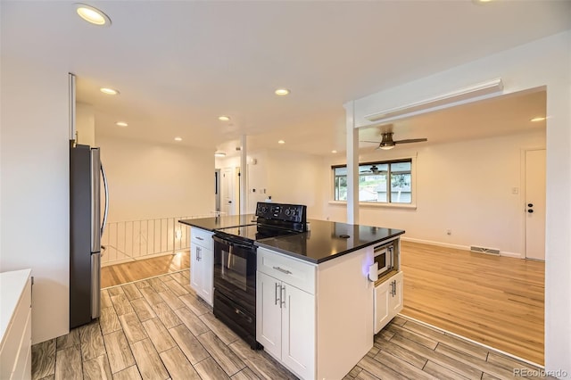 4244 W Monmouth Ave, Littleton, CO 80123 - kitchen featuring appliances with stainless steel finishes, light wood-type flooring, white cabinets, dark countertops, and recessed lighting