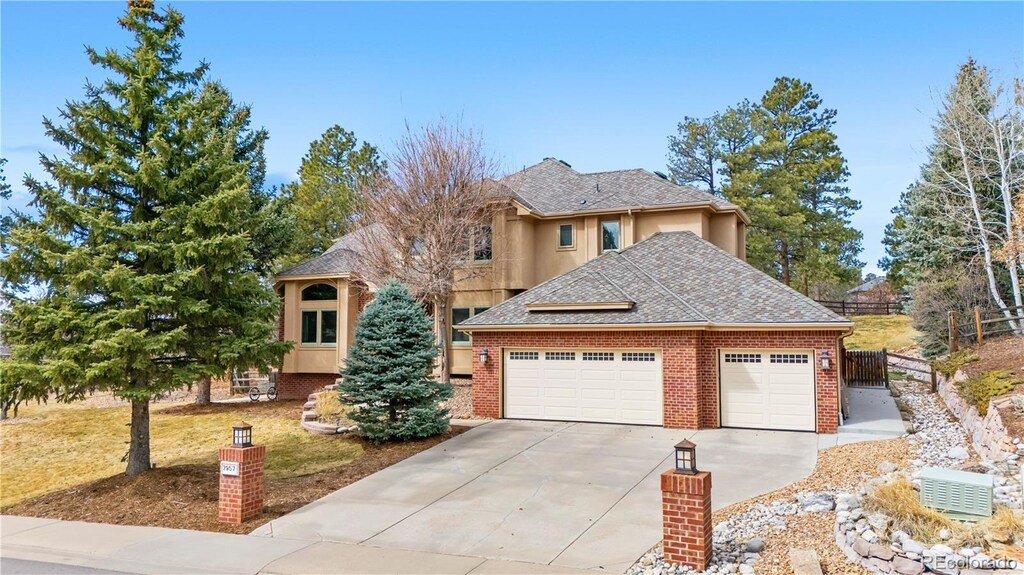 view of front of house with fence, roof with shingles, concrete driveway, an attached garage, and brick siding