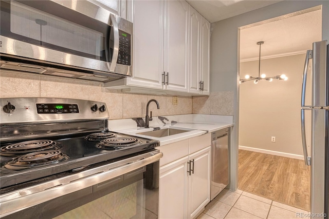 kitchen featuring appliances with stainless steel finishes, sink, white cabinets, and backsplash