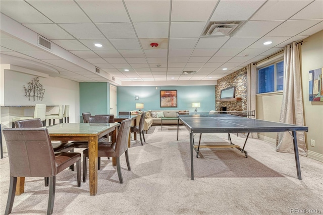 game room featuring light colored carpet, a drop ceiling, and a fireplace