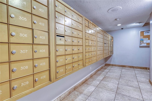 corridor featuring light tile patterned floors, a mail area, and a textured ceiling