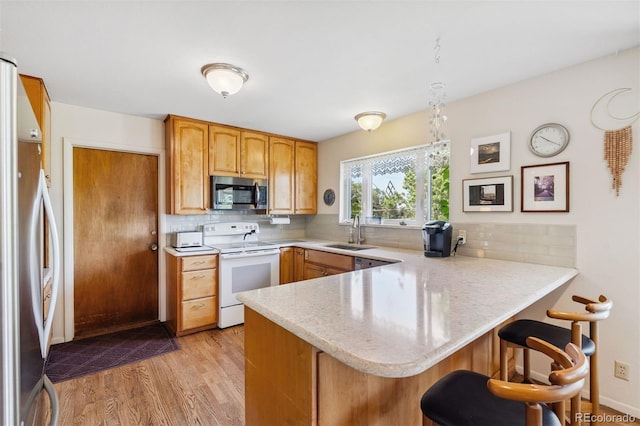 1601 Columbine Pl, Colorado Springs, CO 80907 - kitchen with white range with electric stovetop, stainless steel microwave, a peninsula, and backsplash