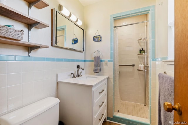 1601 Columbine Pl, Colorado Springs, CO 80907 - full bathroom with tile walls, a shower stall, vanity, and a wainscoted wall