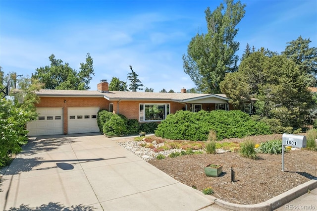 1601 Columbine Pl, Colorado Springs, CO 80907 - single story home with a garage, brick siding, a chimney, and concrete driveway