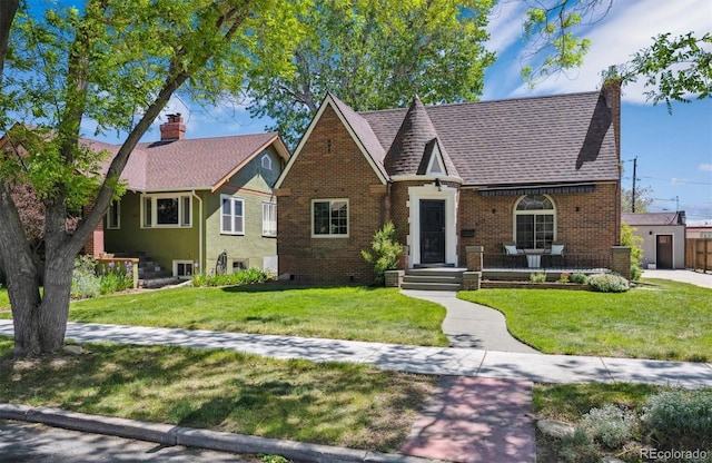 4434 Grove St, Denver, CO 80211 - tudor house with brick siding, a front yard, and a chimney