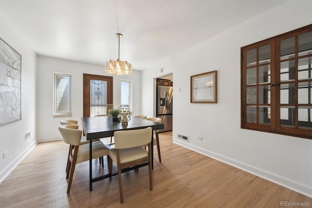 4434 Grove St, Denver, CO 80211 - dining room with a chandelier, light wood-style floors, and baseboards