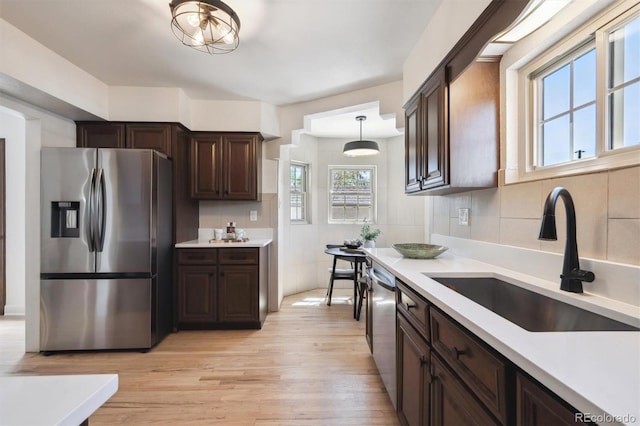4434 Grove St, Denver, CO 80211 - kitchen featuring stainless steel appliances, a sink, light wood finished floors, and dark brown cabinets