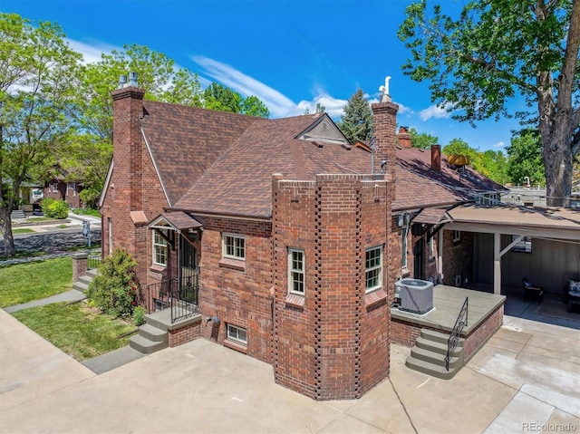 4434 Grove St, Denver, CO 80211 - view of property exterior featuring roof with shingles, a patio area, a chimney, and brick siding