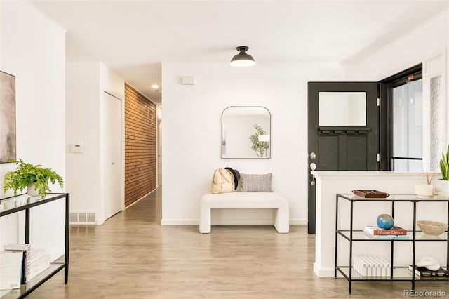 living area with wood finished floors, visible vents, and baseboards