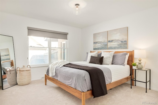 bedroom featuring light carpet and baseboards