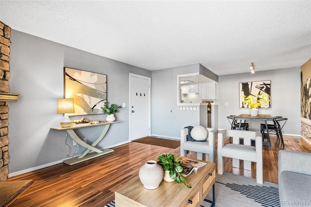 8600 E Alameda Ave Unit 13-108, Denver, CO 80247 - living area featuring wood finished floors, a textured ceiling, and a stone fireplace