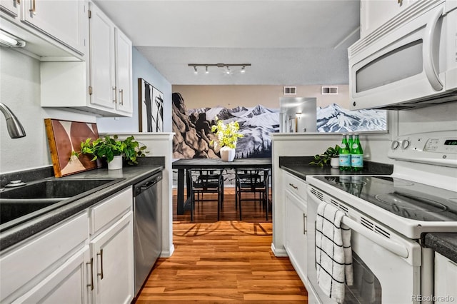 8600 E Alameda Ave Unit 13-108, Denver, CO 80247 - kitchen featuring white appliances, dark countertops, light wood-style floors, white cabinets, and track lighting