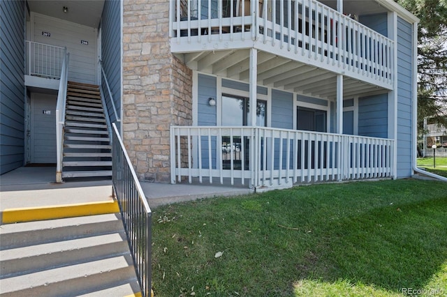 8600 E Alameda Ave Unit 13-108, Denver, CO 80247 - view of side of property featuring stairway, a yard, covered porch, stone siding, and a balcony