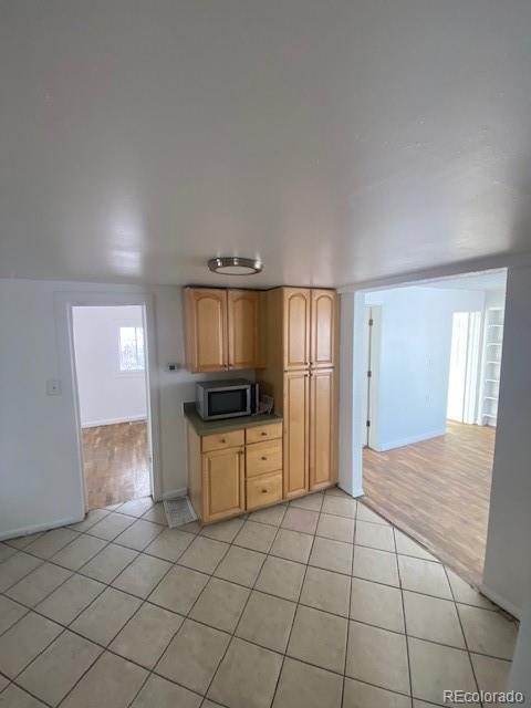 kitchen featuring light tile patterned flooring and light brown cabinetry