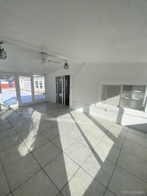 spare room with ceiling fan and light tile patterned flooring