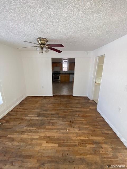 spare room featuring ceiling fan, sink, dark hardwood / wood-style floors, and a textured ceiling