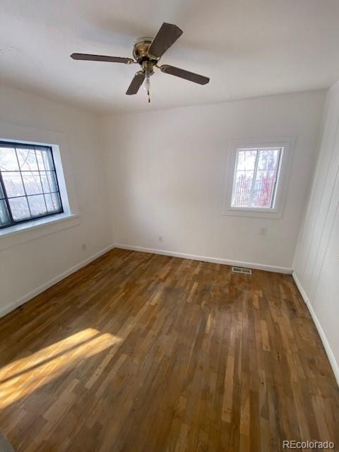 spare room with dark hardwood / wood-style floors and ceiling fan