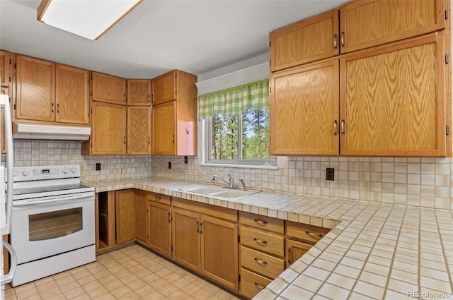 561 Quartz Cir, Bailey, CO 80421 - kitchen with white electric range oven, under cabinet range hood, backsplash, tile counters, and brown cabinetry