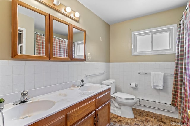 561 Quartz Cir, Bailey, CO 80421 - bathroom featuring double vanity, tile walls, wainscoting, a baseboard heating unit, and a shower with shower curtain