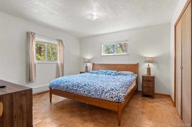 561 Quartz Cir, Bailey, CO 80421 - bedroom featuring multiple windows, baseboard heating, a textured ceiling, and a closet
