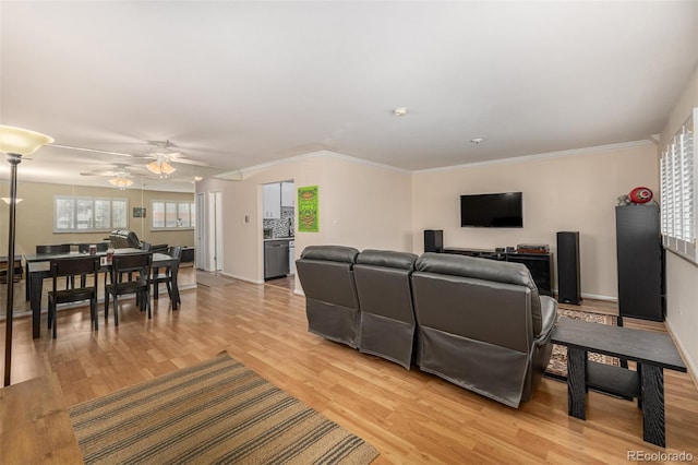 living room featuring ceiling fan, crown molding, and light hardwood / wood-style floors