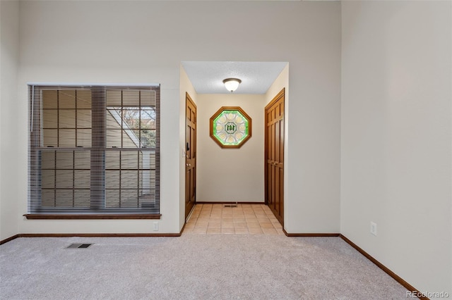 doorway featuring light carpet and a textured ceiling