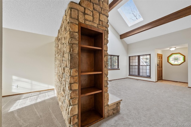 unfurnished living room with beam ceiling, a skylight, high vaulted ceiling, a textured ceiling, and light carpet