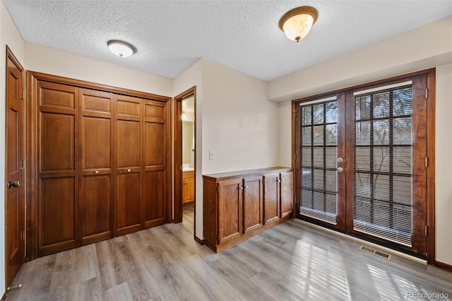 doorway featuring light hardwood / wood-style floors and a textured ceiling