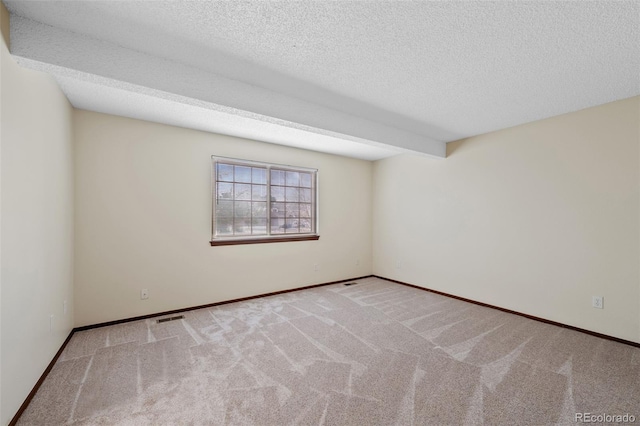 carpeted spare room featuring a textured ceiling