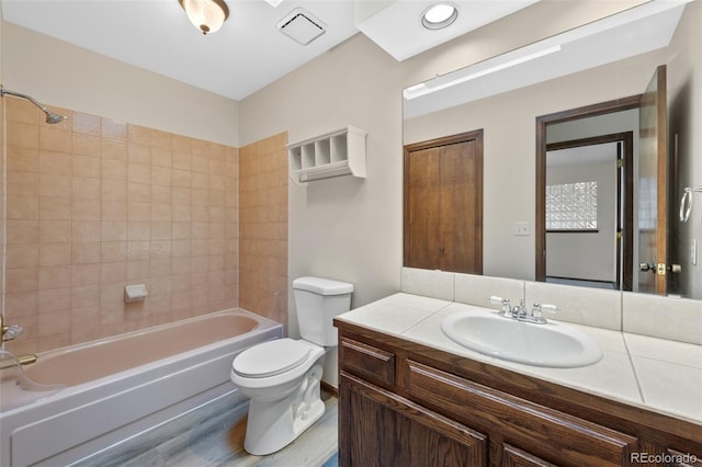 full bathroom with vanity, toilet, tiled shower / bath combo, and wood-type flooring