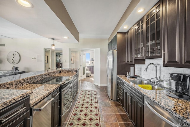 kitchen featuring sink, dark brown cabinets, stainless steel appliances, and stone countertops