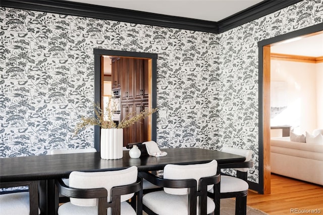 dining area featuring crown molding and hardwood / wood-style floors