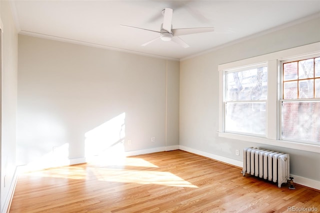 spare room with crown molding, radiator heating unit, and light hardwood / wood-style floors