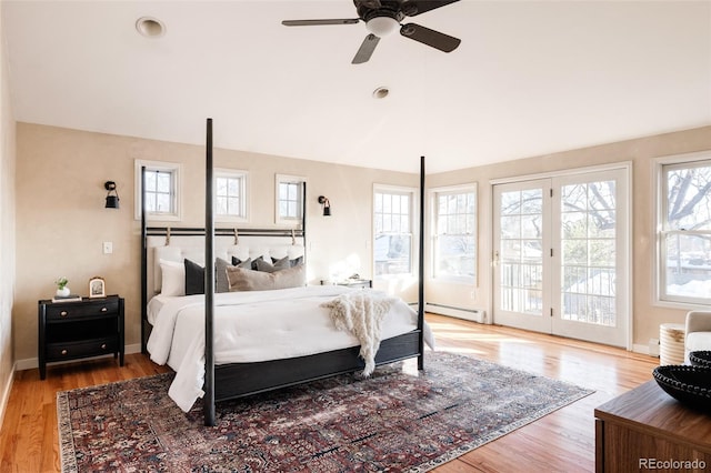 bedroom featuring light wood-type flooring, access to outside, ceiling fan, and baseboard heating