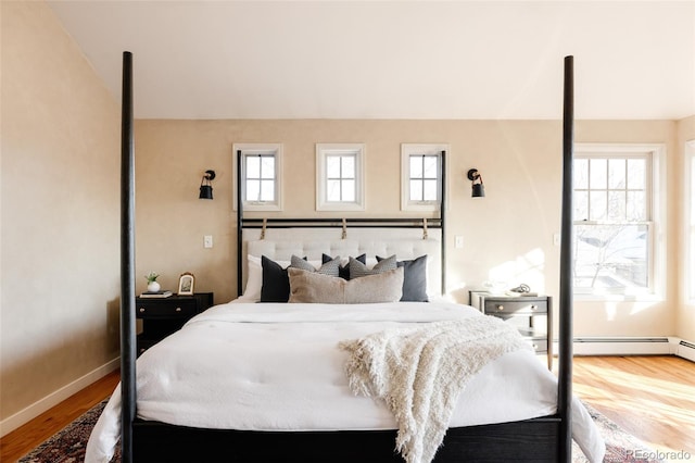 bedroom with hardwood / wood-style flooring and a baseboard radiator