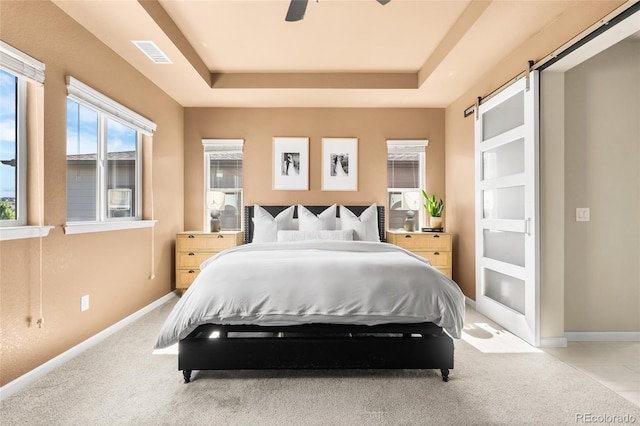 4778 Ravencrest Pl, Castle Rock, CO 80108 - bedroom with a raised ceiling, a barn door, light carpet, and a ceiling fan