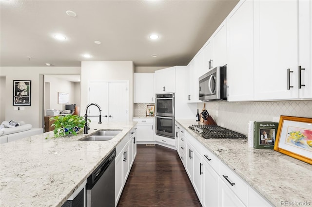 4778 Ravencrest Pl, Castle Rock, CO 80108 - kitchen with stainless steel appliances, backsplash, white cabinetry, light stone countertops, and recessed lighting